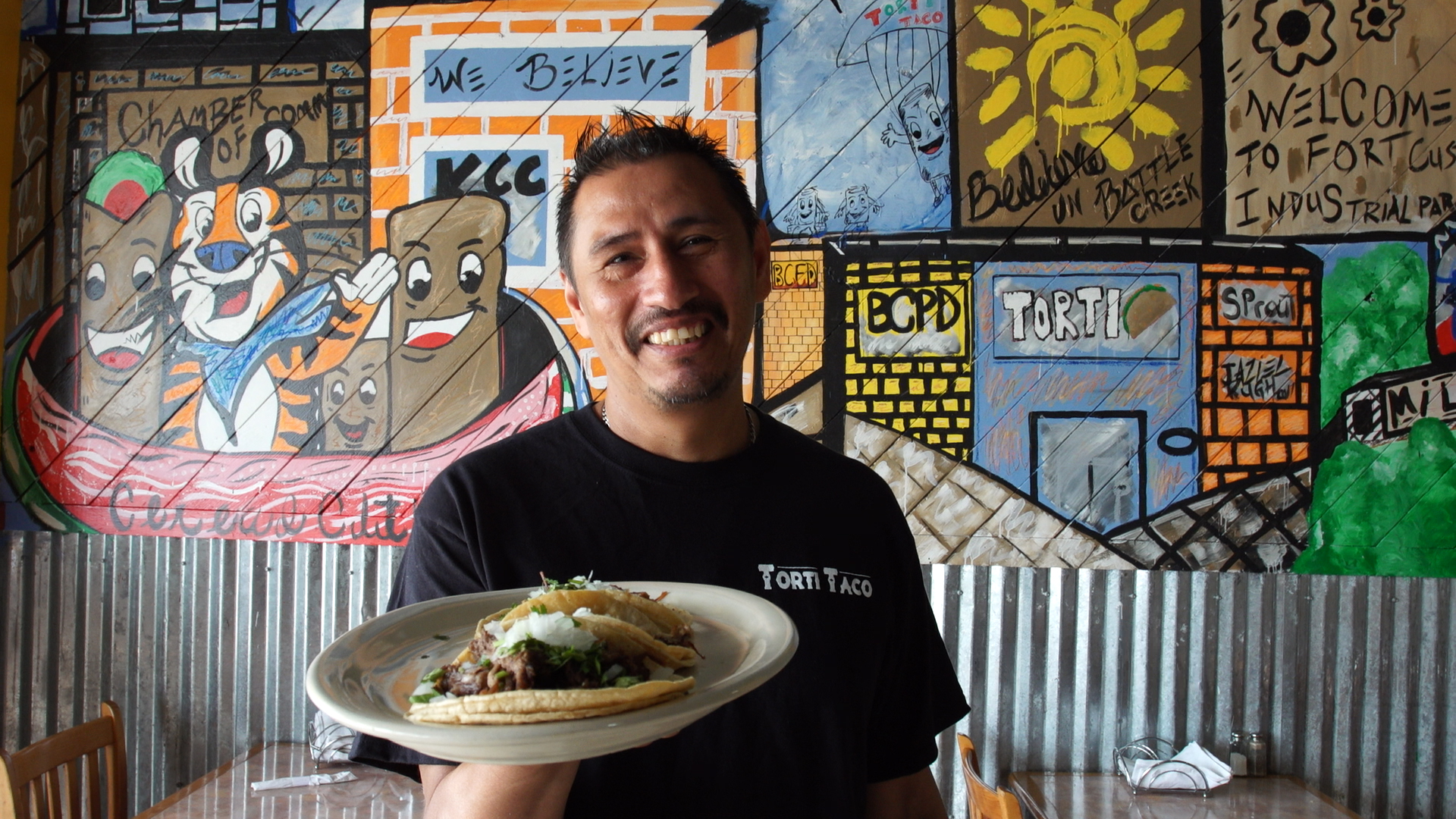 Javier poses with a plate of tacos.